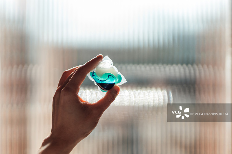 女性手握着洗衣液胶囊图片素材