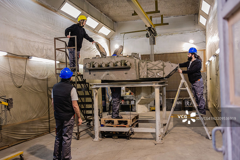 工程师在工厂检查和组装军用坦克炮塔图片素材
