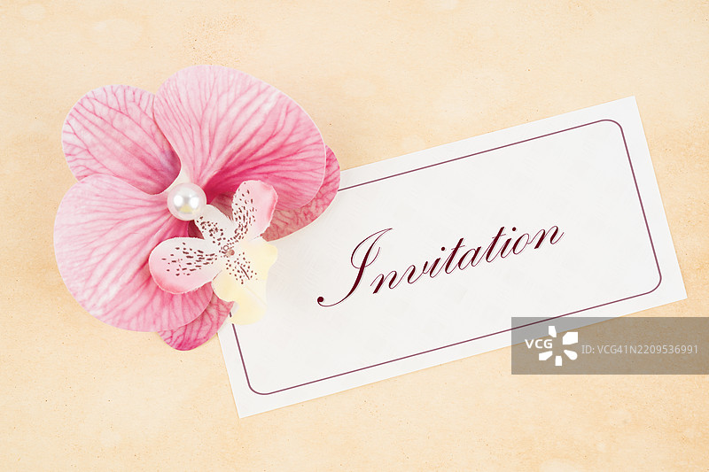 带有粉色兰花的邀请卡，背景为旧棕色纸张。图片素材