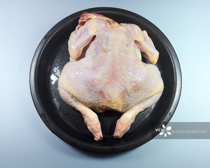 整只生鸡在烹饪锅上图片素材