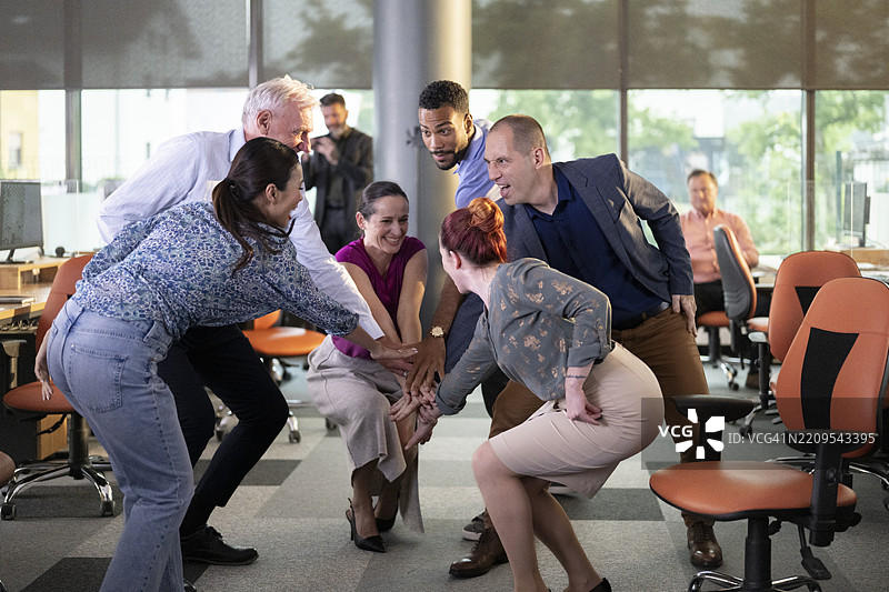 快乐多元化的商业团队在现代开放式办公室庆祝成功图片素材