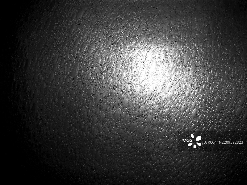 黑白玻璃表面带有气泡并背光。粗糙的纹理。图片素材