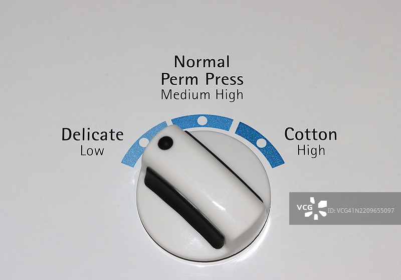 白色顶装洗衣机上的控制旋钮设置为精细洗涤图片素材