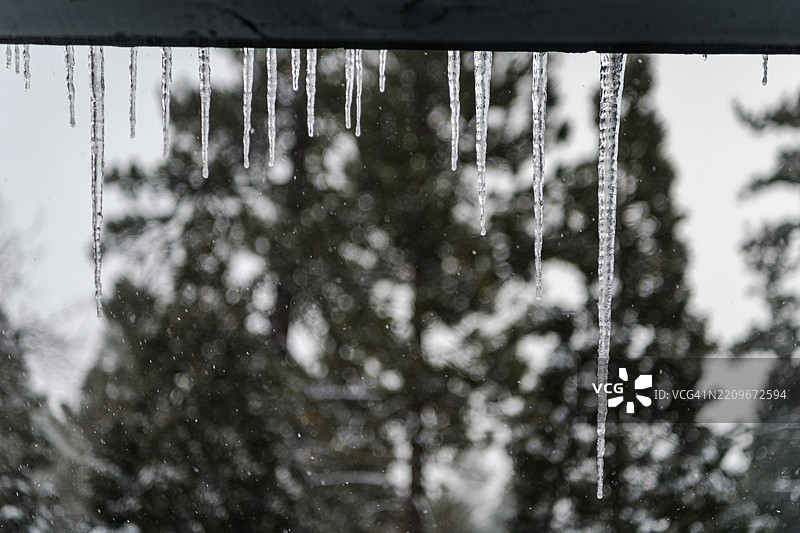 冬季的水晶匕首：冰柱装点山间小屋图片素材