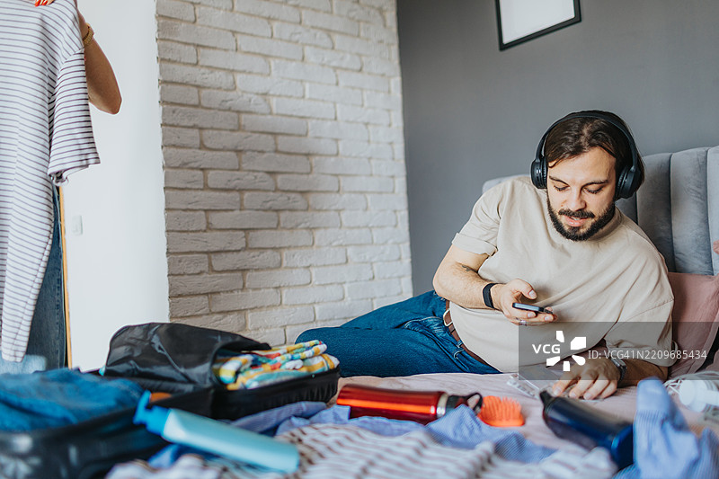 快乐的年轻情侣在家准备度假图片素材