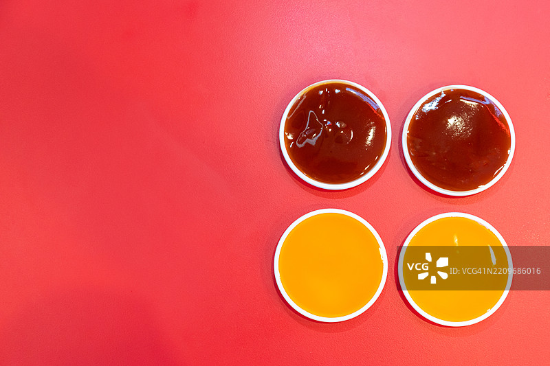 红色桌子上的番茄酱和辣椒酱图片素材