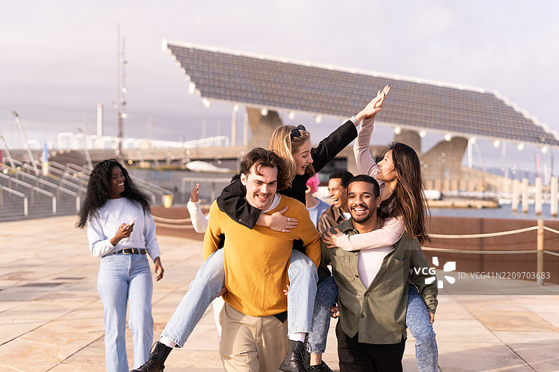 年轻人在海边背着朋友图片素材