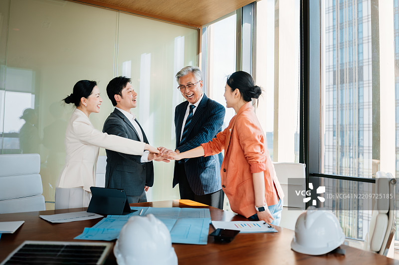 快乐的亚洲商务人士在办公室的轻松会议中互相击掌。图片素材