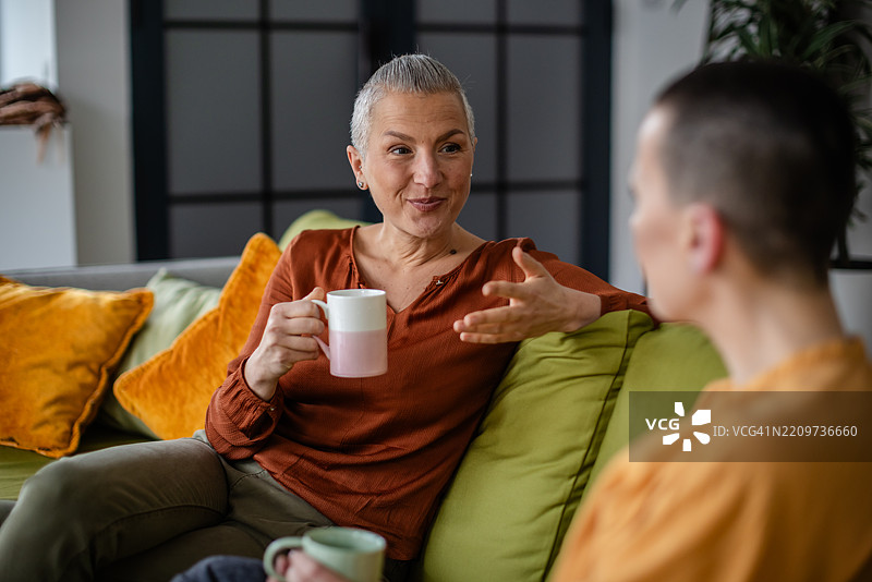 两位女性在家中分享真挚对话，友谊与支持伴随肿瘤康复过程。图片素材