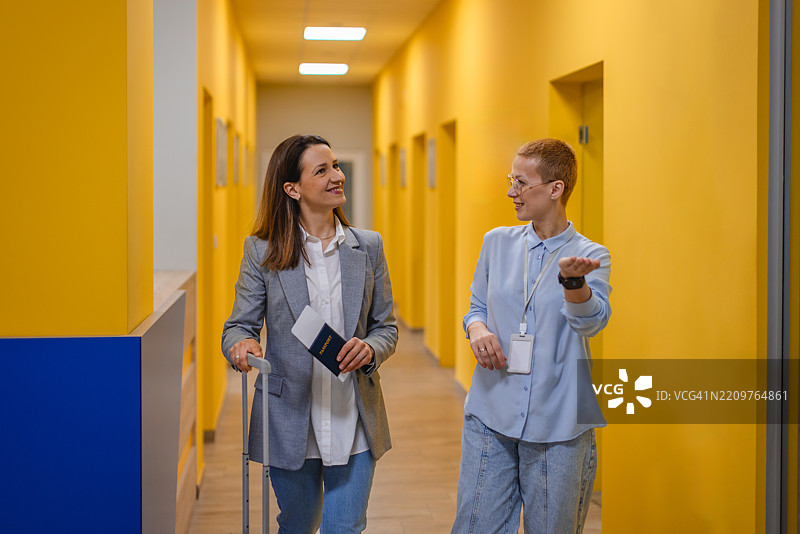 年轻女性抵达酒店前台办理入住，探索充满活力的大堂区域图片素材