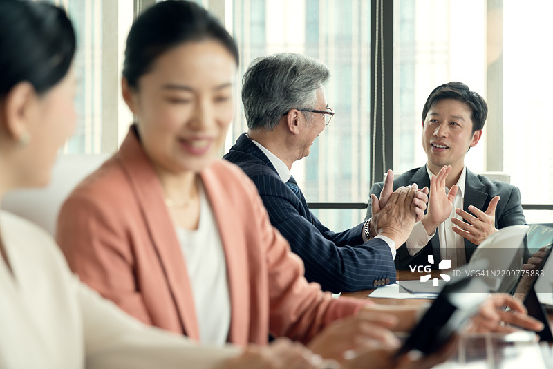 亚洲商业精英在办公室讨论商业计划。图片素材
