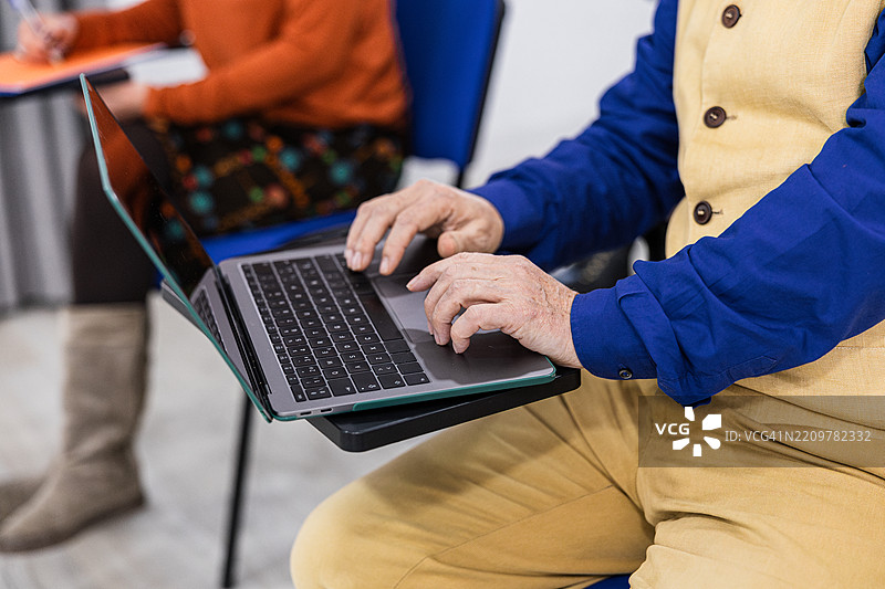 老年学生在成人学习班上使用笔记本电脑图片素材