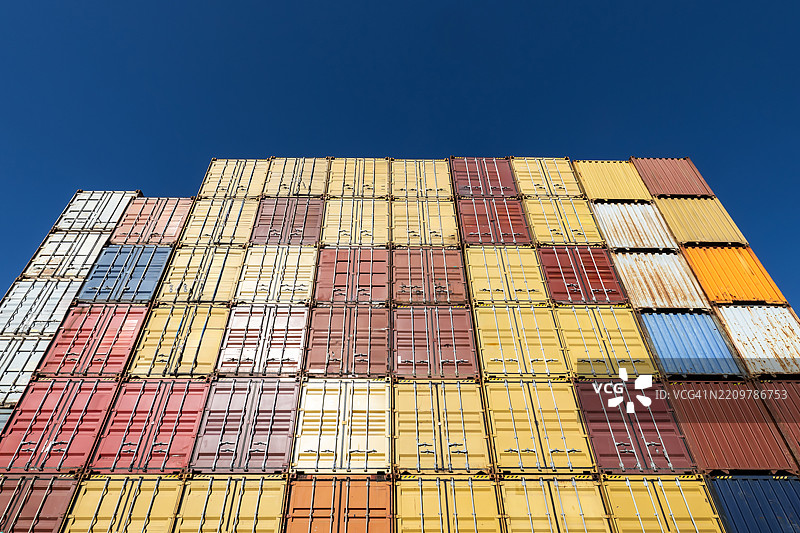 许多堆叠集装箱的正面视图，背景是蓝天图片素材