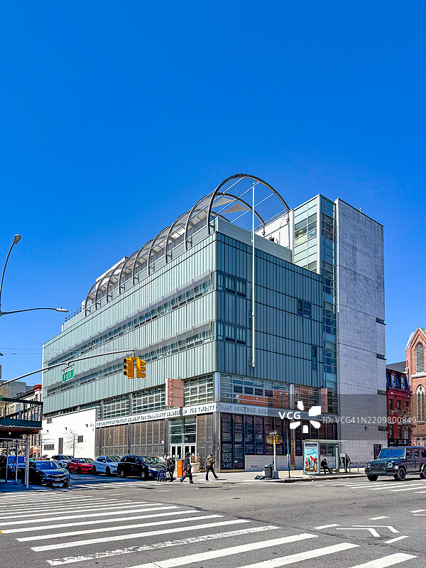 人们在纽约市汉密尔顿高地的西152街附近走过P.S./I.S. 210这所现代学校。图片素材