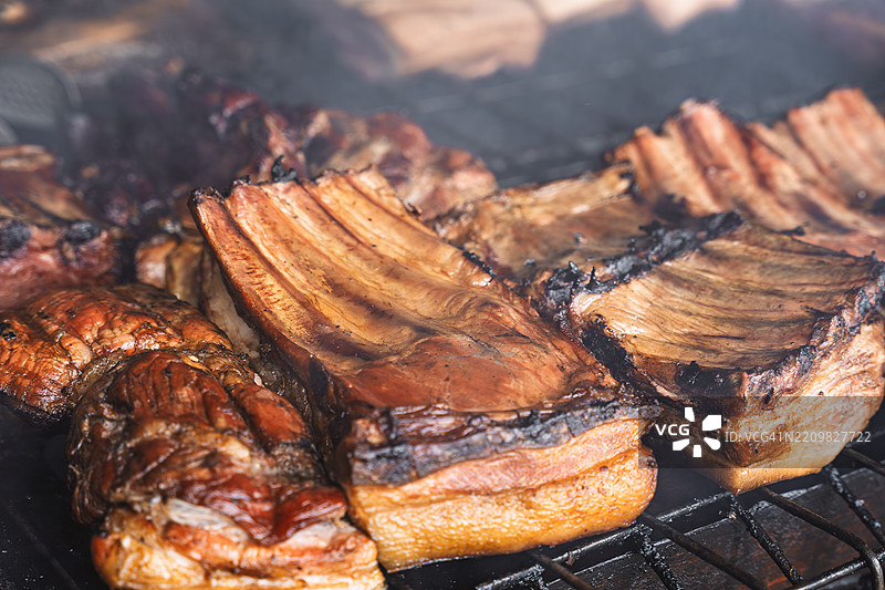 烟熏野猪肋骨在烤架上烤制，伴随烟雾图片素材
