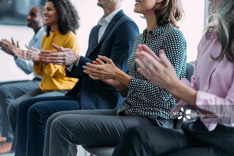 商务人士在会议厅的研讨会上热烈鼓掌。图片素材