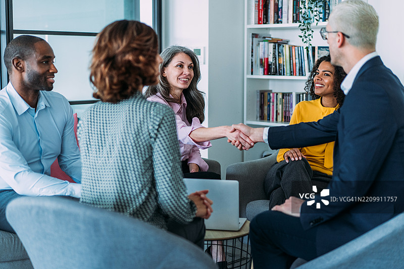 商界人士在桌子对面握手。图片素材
