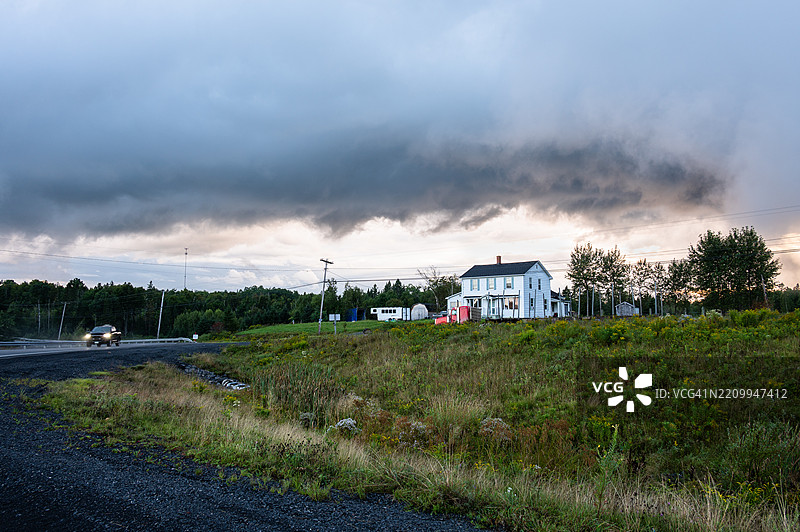 新不伦瑞克省麦吉夫尼村附近乡村房屋上空的暴风云图片素材