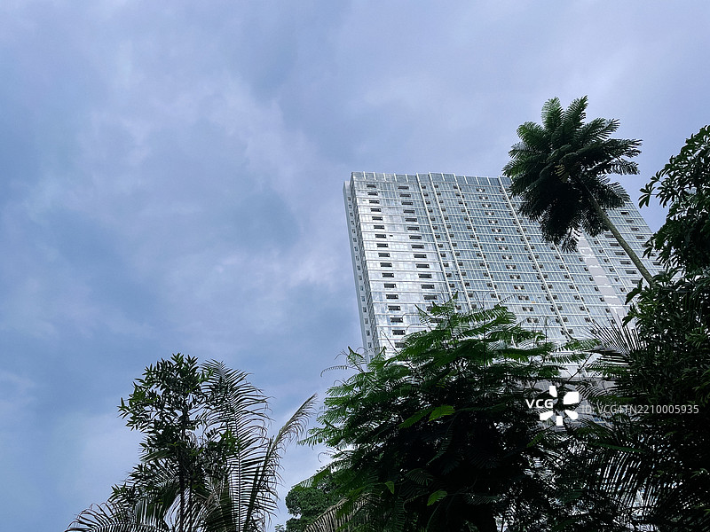 高层办公大楼被绿地环绕 - 自然与工业的共存图片素材