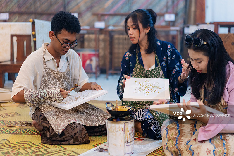 一群不同性别的人一起练习传统蜡染技艺图片素材