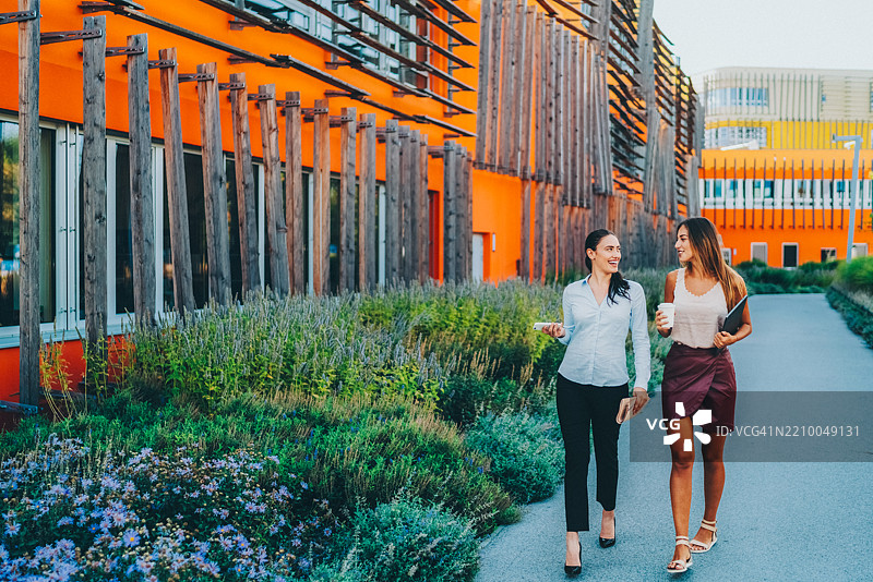 两位自信的女商人在现代办公大楼附近走动图片素材