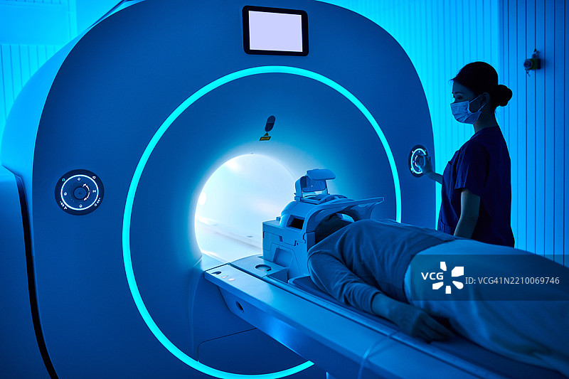 女性护士在MRI扫描室操作MRI扫描仪图片素材