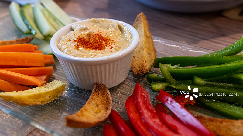 鹰嘴豆泥配烤面包、胡萝卜、黄瓜、红椒和青椒图片素材