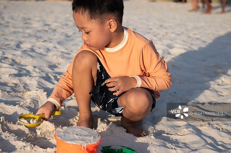 一个东南亚男孩在户外的海滩上玩耍图片素材