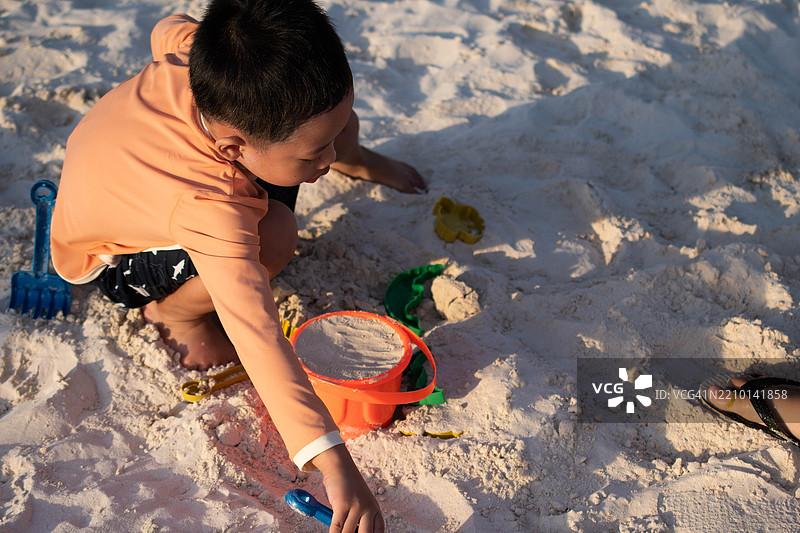 一个东南亚男孩在户外的海滩上玩耍图片素材