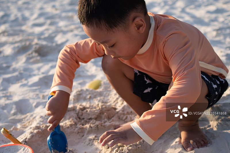 一个东南亚男孩在户外的海滩上玩耍图片素材