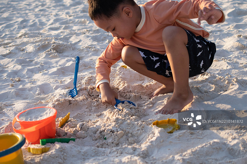 一个东南亚男孩在户外的海滩上玩耍图片素材