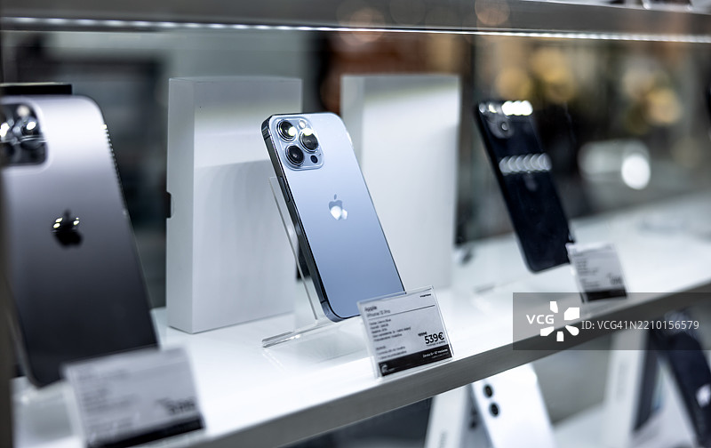 新款苹果iPhone在商店货架上。电子商店中的智能手机展示。图片素材