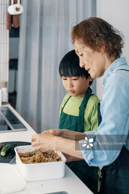 祖母和孙子一起用传统日本发酵腌菜的材料烹饪。图片素材