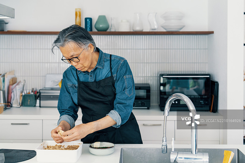 一位老年男子即将品尝传统日本腌菜。图片素材