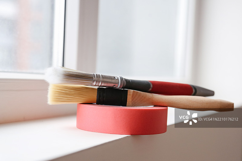 改善新公寓，粉色胶带和新刷子用于粉刷墙壁图片素材