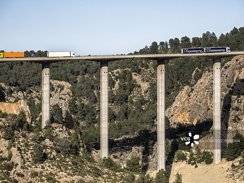 高速公路桥梁上有卡车穿越山间峡谷。图片素材
