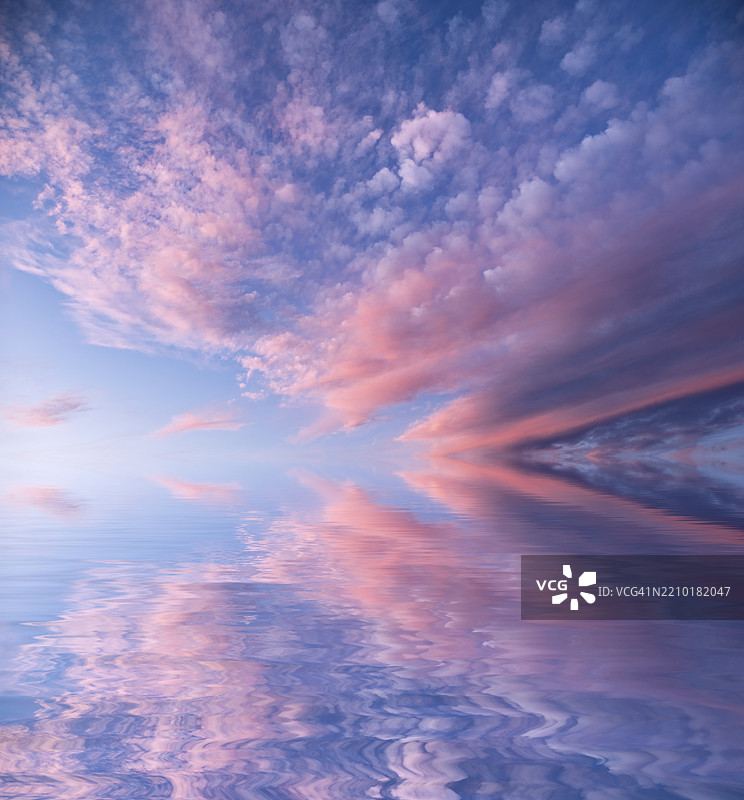 日落时分，小高云在平静的水面上倒影。图片素材