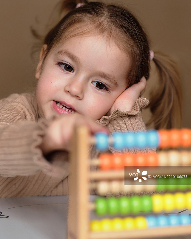 可爱女孩在玩算盘玩具图片素材