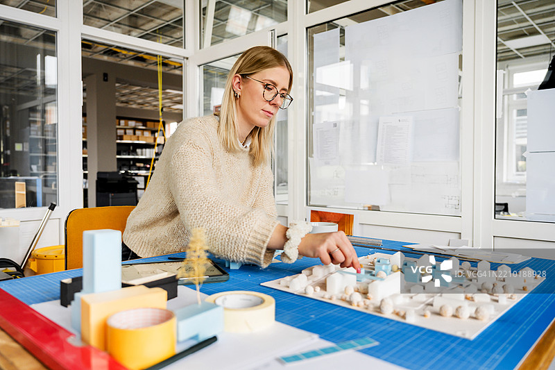 专注的建筑师在详细模型中调整建筑物图片素材