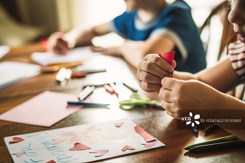 小女孩和小男孩为妈妈制作贺卡图片素材
