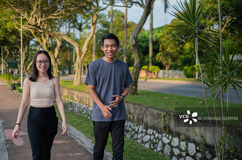 亚洲成年男女在湖边城市公园晨曦中一起进行热身锻炼，健康生活方式的照片图片素材