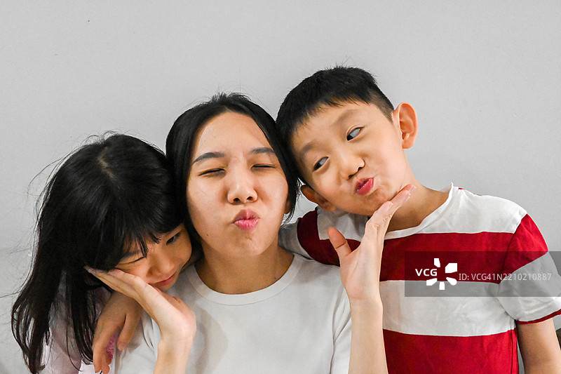 孩子们早上醒来时与妈妈一起度过快乐的时光，享受早餐前的乐趣。图片素材