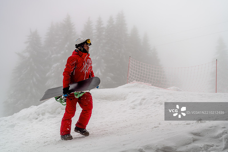 滑雪者在雪山上行走，背景是雾气弥漫的树木图片素材