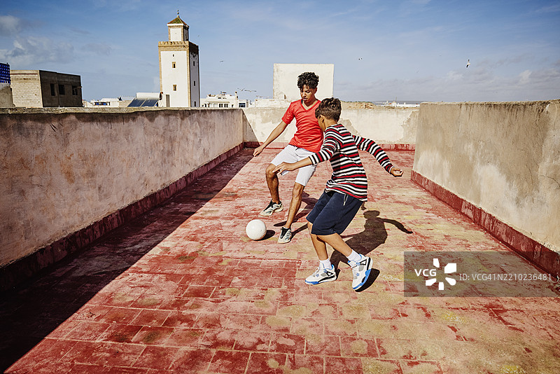 摩洛哥屋顶上朋友们进行一对一的足球比赛的广角镜头图片素材