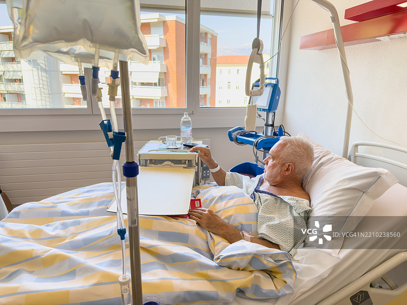 躺在医院病床上的老人望着窗外的景色图片素材