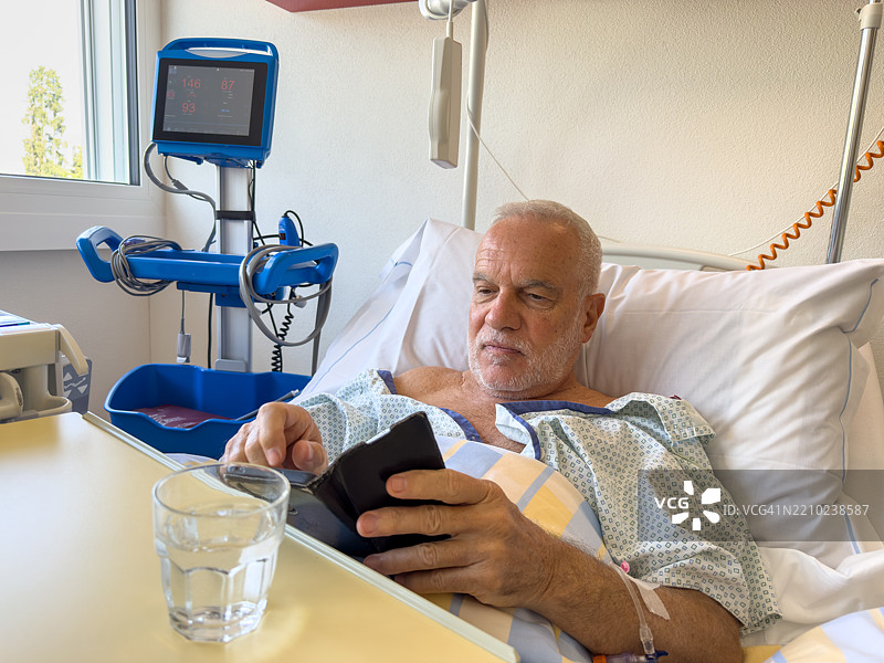 老年人在医院病床上使用手机图片素材