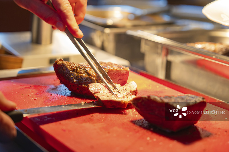 一位厨师在砧板上精准地切割一块美味的肉，欧洲霍夫，德国，科宁斯巴赫施泰因，欧洲图片素材