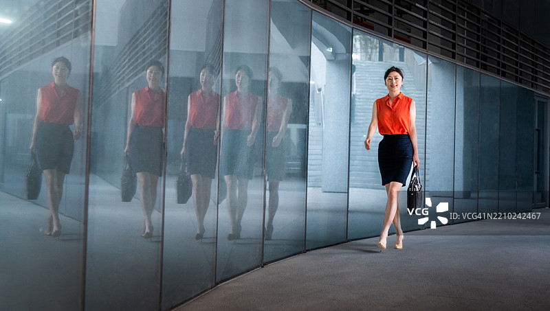 人行道上走动的女商人的倒影图片素材