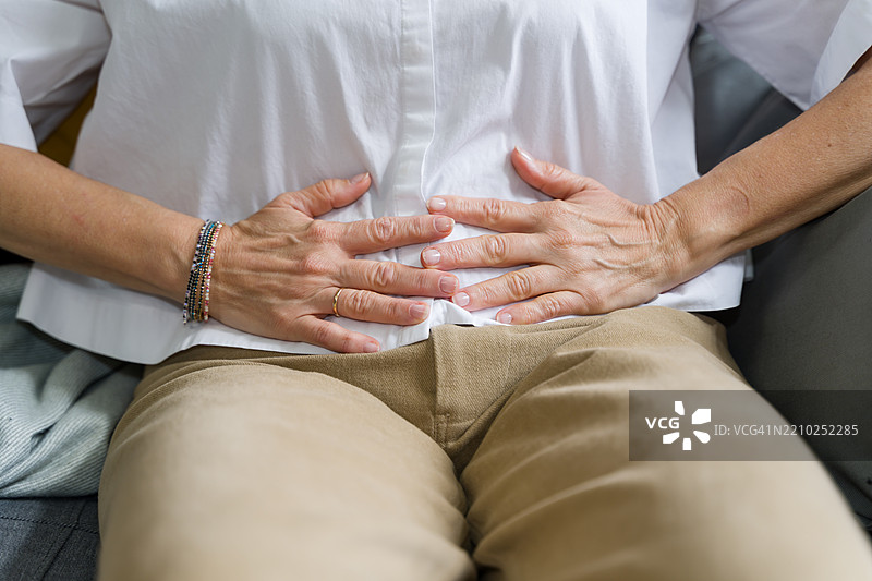 女性因腹痛而捂着肚子图片素材