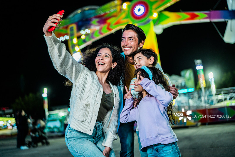 家庭在游乐园拍自拍照图片素材